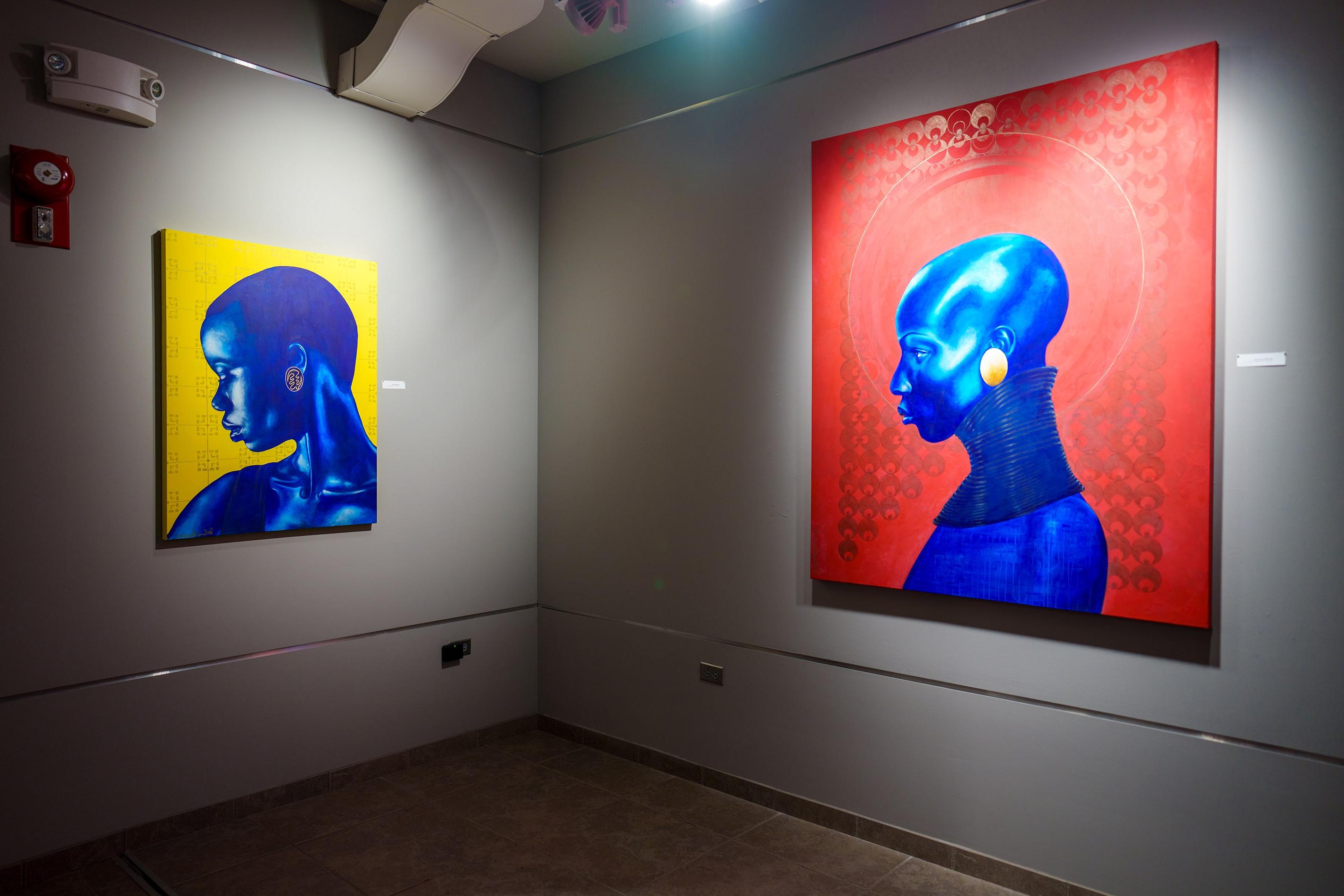 A pair of paintings on display at an exhibition